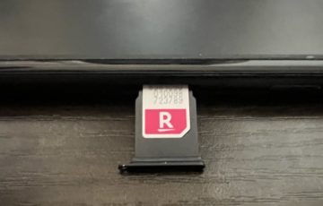Rakuten最強プラン(データタイプ)のSIMカードをiPhoneのSIMスロットに挿入している写真